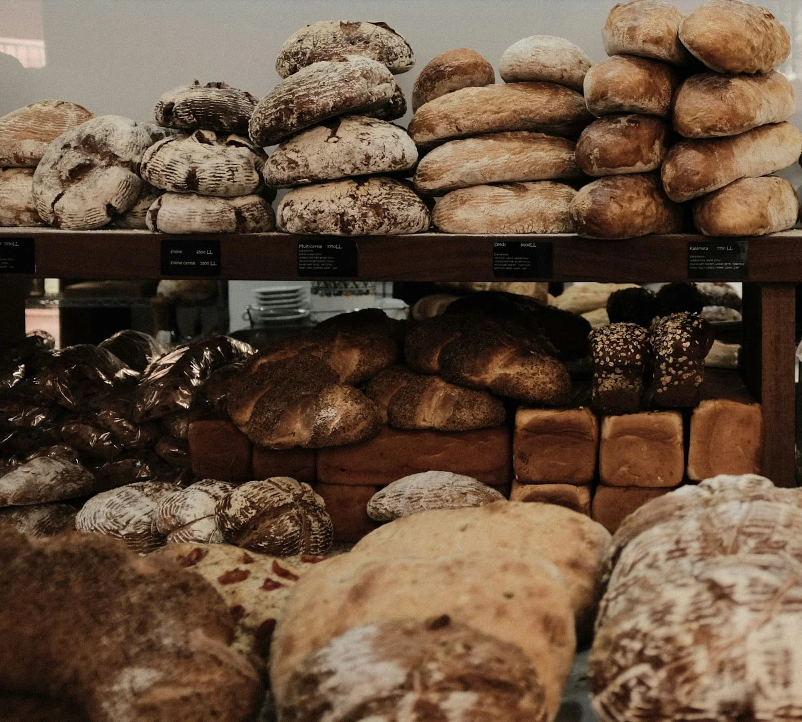 Fresh bread arranged on wooden bakery shelves